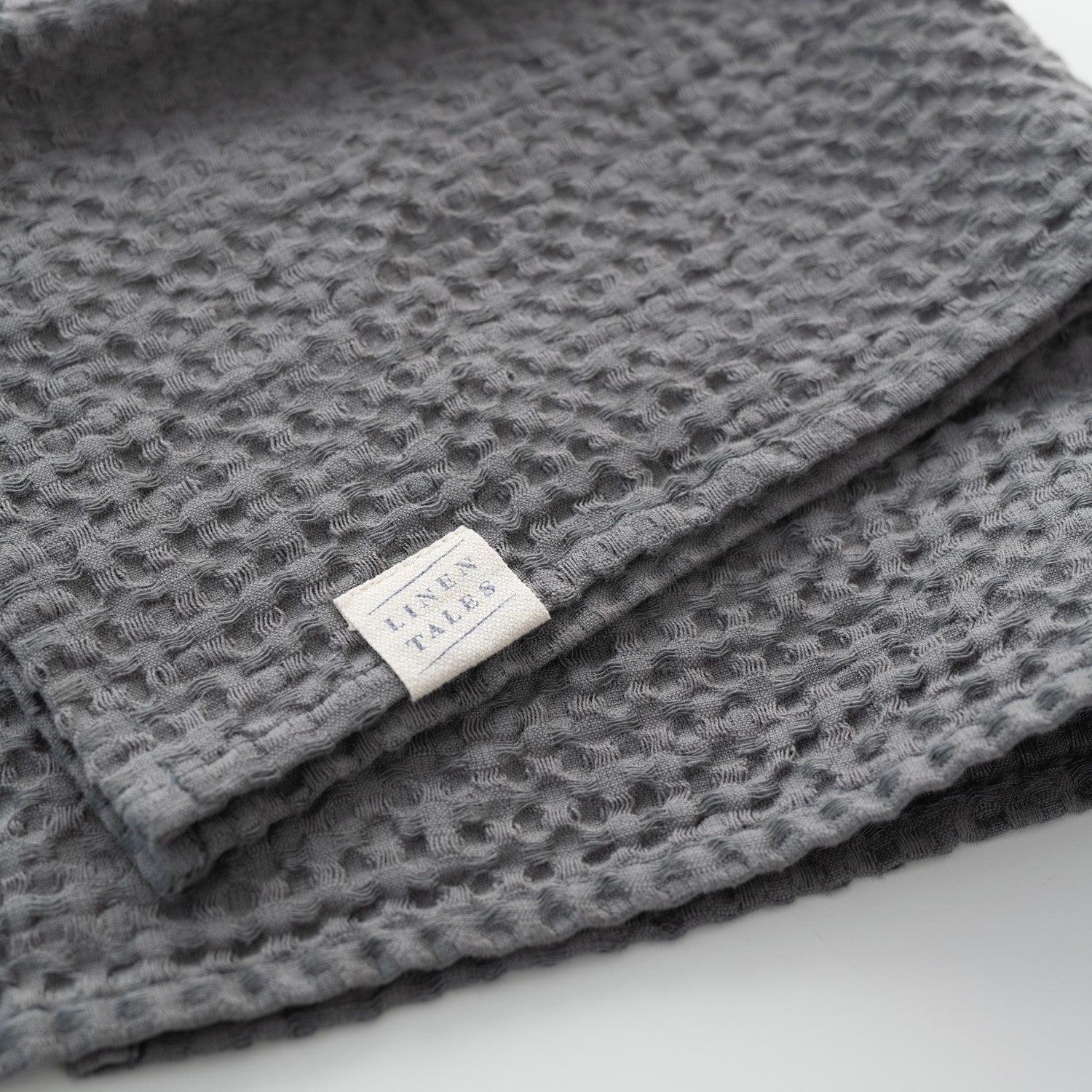 Dark grey linen-cotton towel folded for open shelf styling