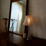 Pleat table lamp photographed in a home setting.